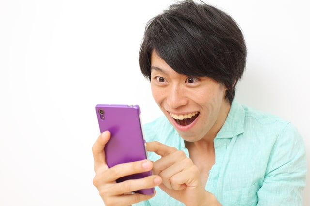 スマホを見て喜んでいる人